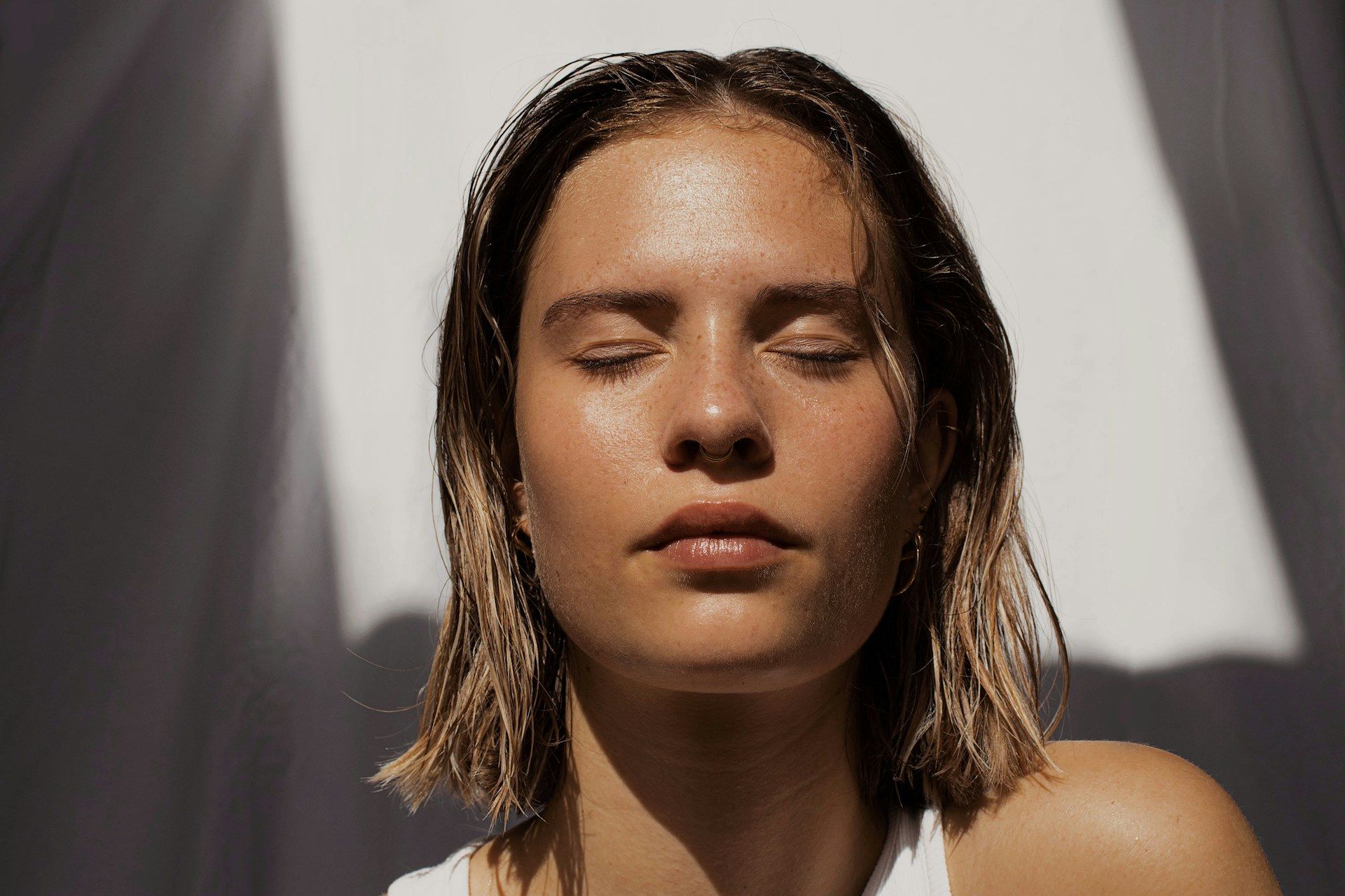 Woman in warm golden light, eyes closed, at peace
